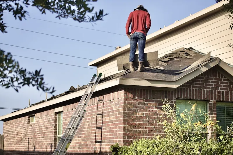 Professional roofer working on a residential roof in Williams